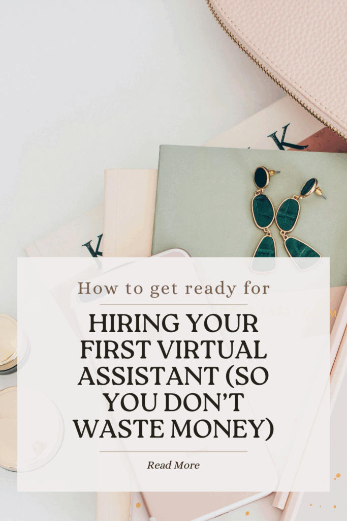 Styled flat lay featuring notebooks, green statement earrings, and pink accessories on neutral background. White text overlay displays blog title 'How to get ready for HIRING YOUR FIRST VIRTUAL ASSISTANT (SO YOU DON'T WASTE MONEY)' with 'Read More' call-to-action
